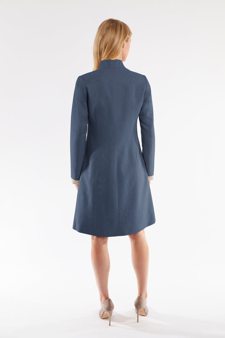 Woman wearing a navy blue coat on a white background