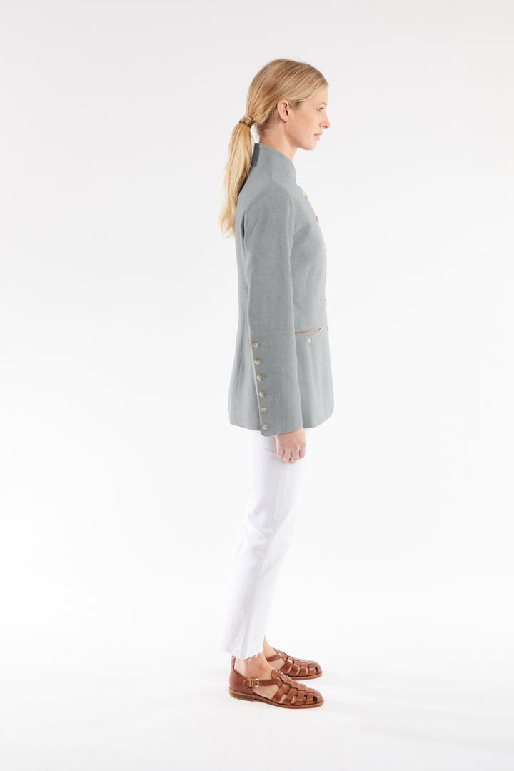 Woman wearing a gray jacket with ivory buttons on a white background