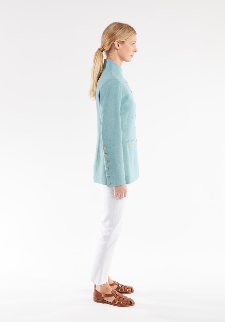 Side view of woman wearing light blue linen jacket with buttons down the sleeve