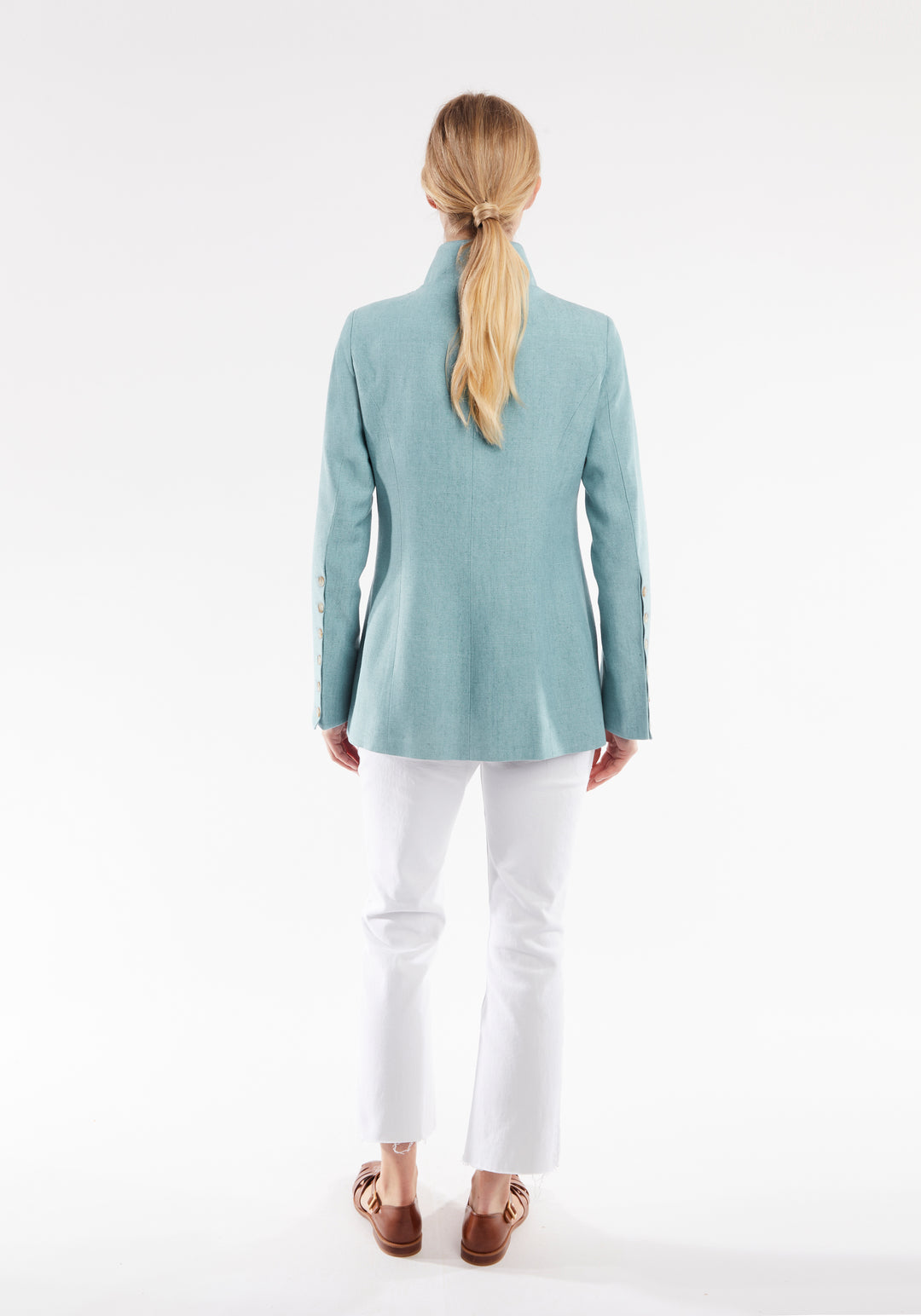 Woman wearing light blue linen jacket with buttons down the sleeve