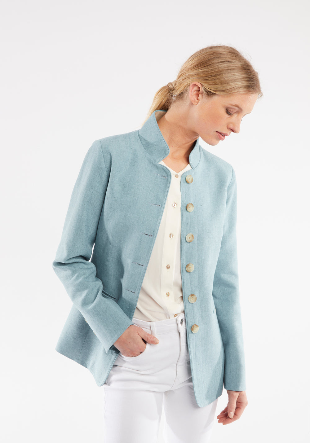 Woman wearing light blue linen jacket with buttons down the front