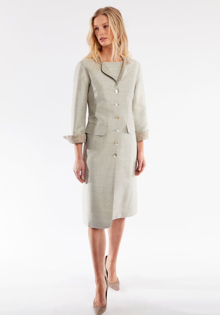 Woman wearing dove grey coat with cuff detailing and mother of pearl buttons