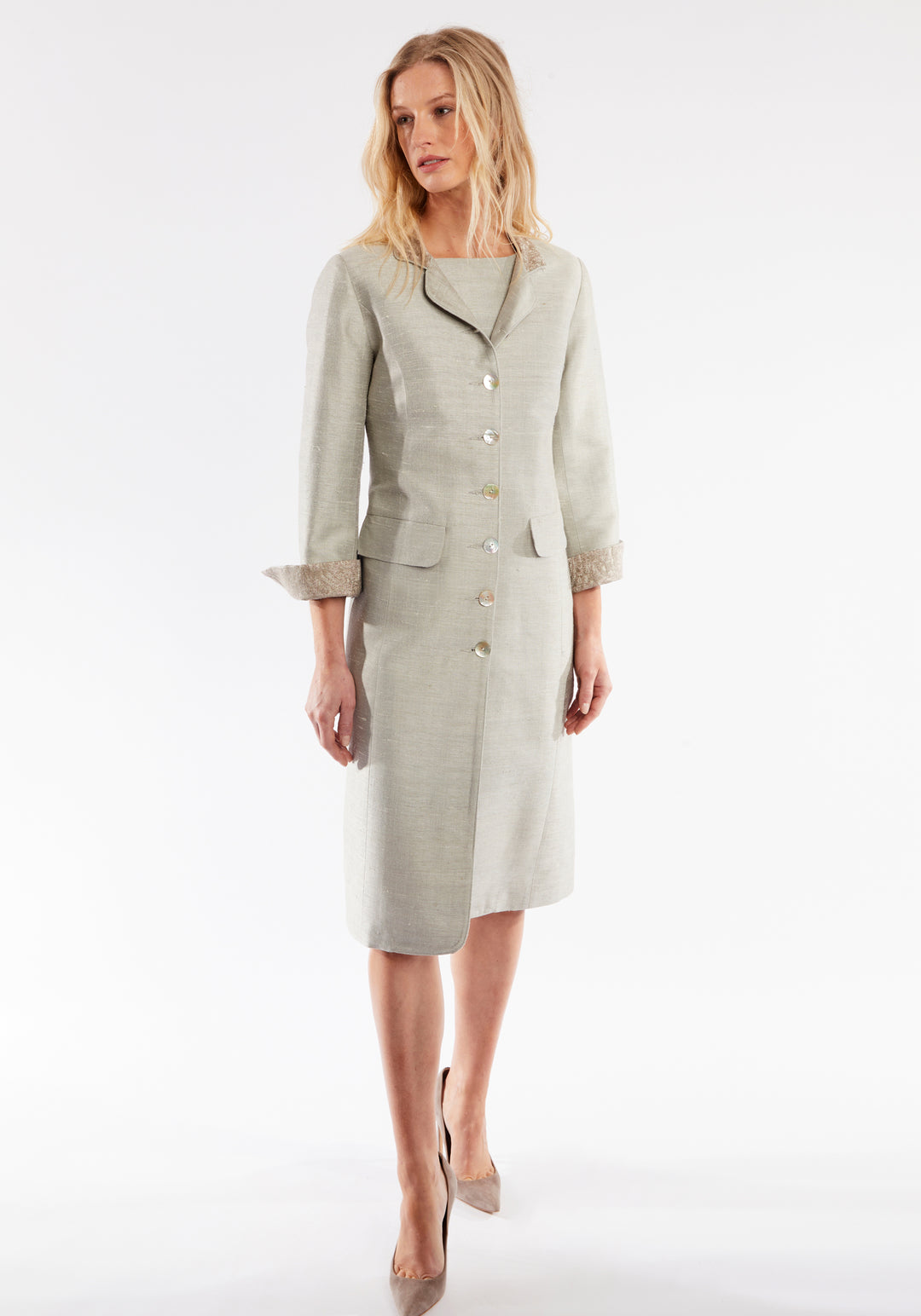 Woman wearing dove grey coat with cuff detailing and mother of pearl buttons