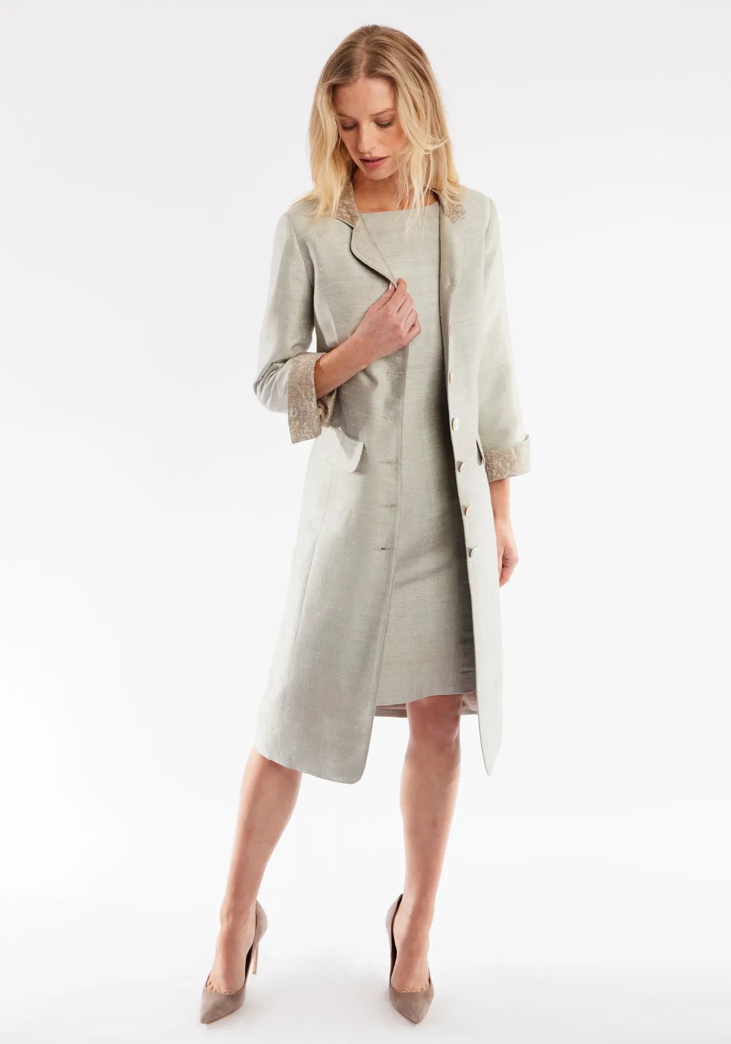 Woman wearing a light gray coat on a white background