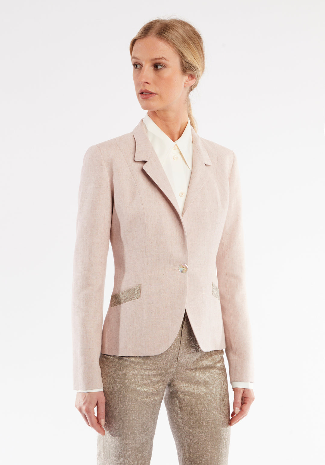 Woman wearing light pink jacket with beige pocket and collar detailing. Collar folded down.