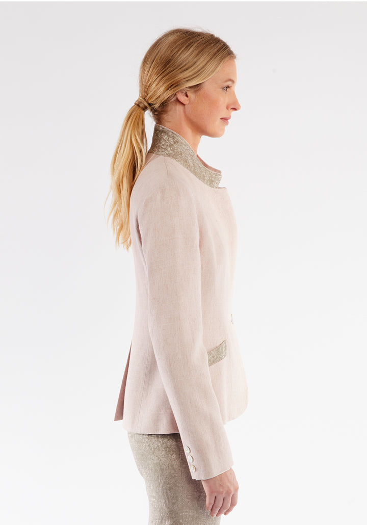 Side view of a woman wearing light pink jacket with beige pocket and collar detailing