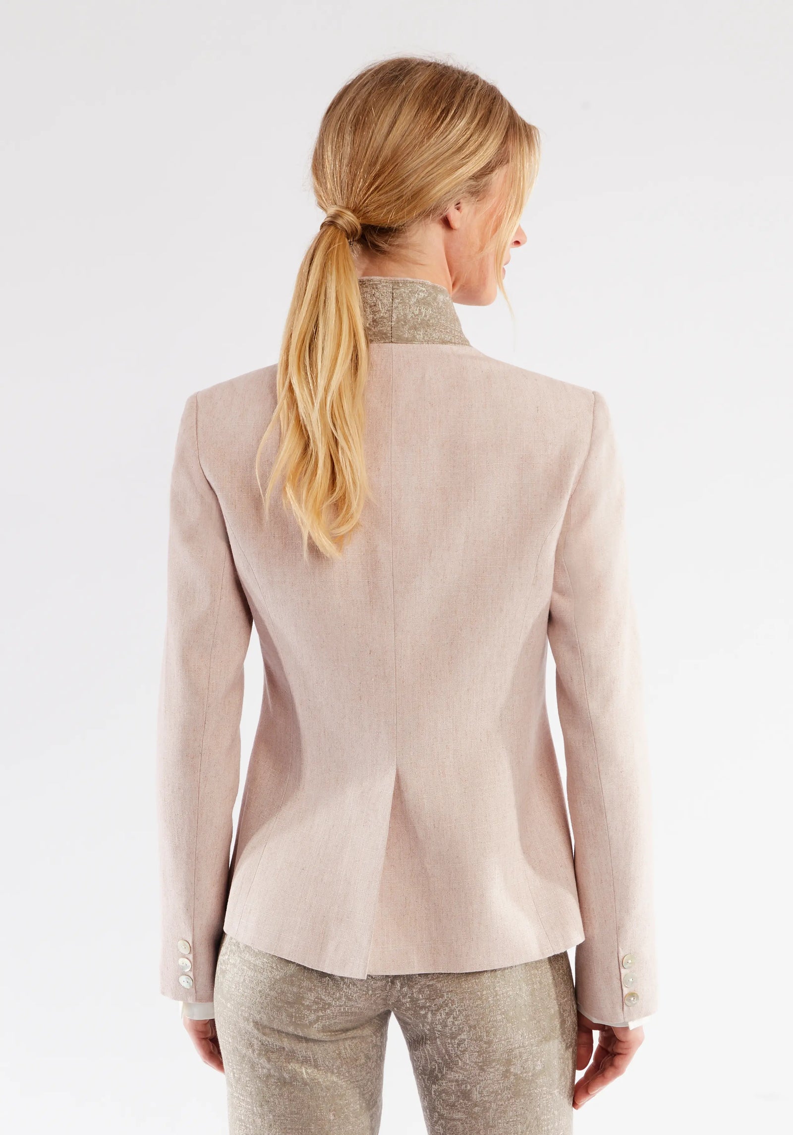 Woman wearing a light pink blazer on a white background