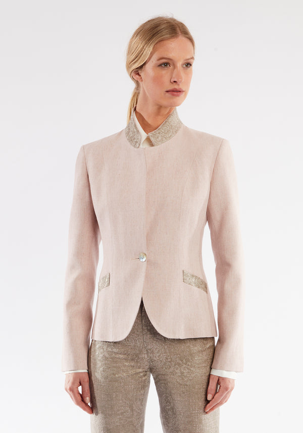 Woman wearing light pink jacket with beige pocket and collar detailing