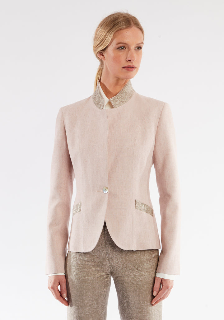 Woman wearing light pink jacket with beige pocket and collar detailing