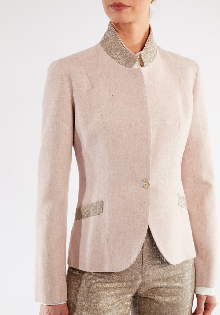 Woman wearing light pink jacket with beige pocket and collar detailing