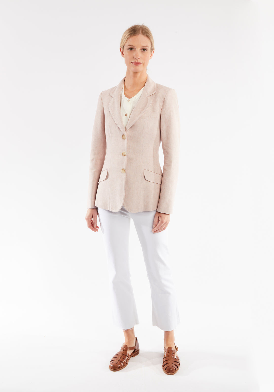Woman wearing light pink jacket with buttons down the front