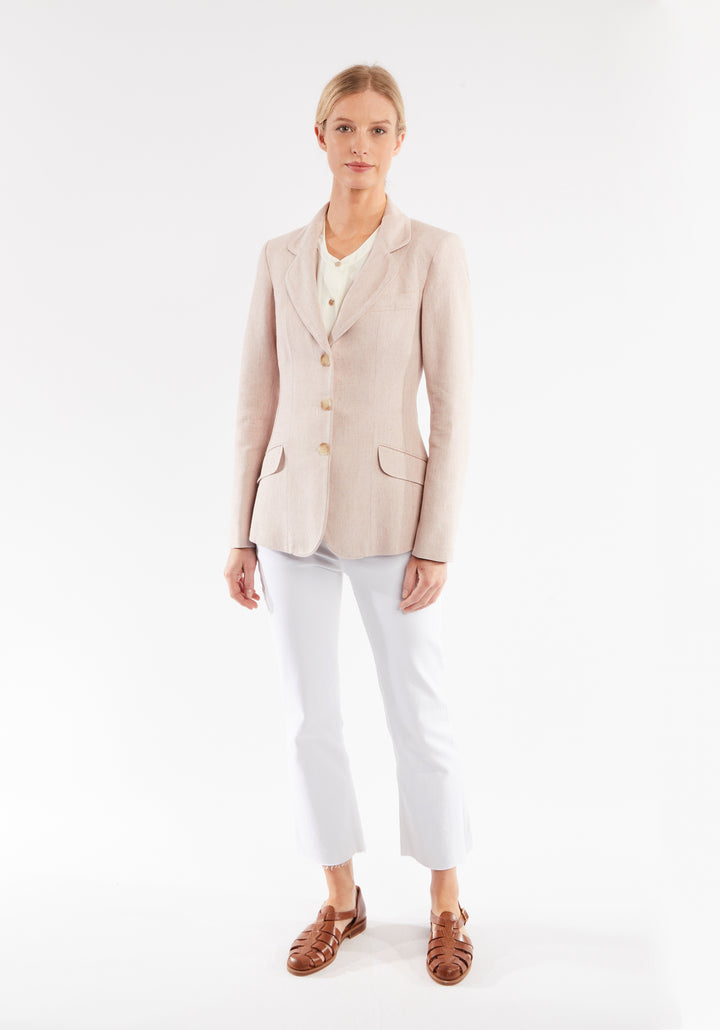Woman wearing light pink jacket with buttons down the front
