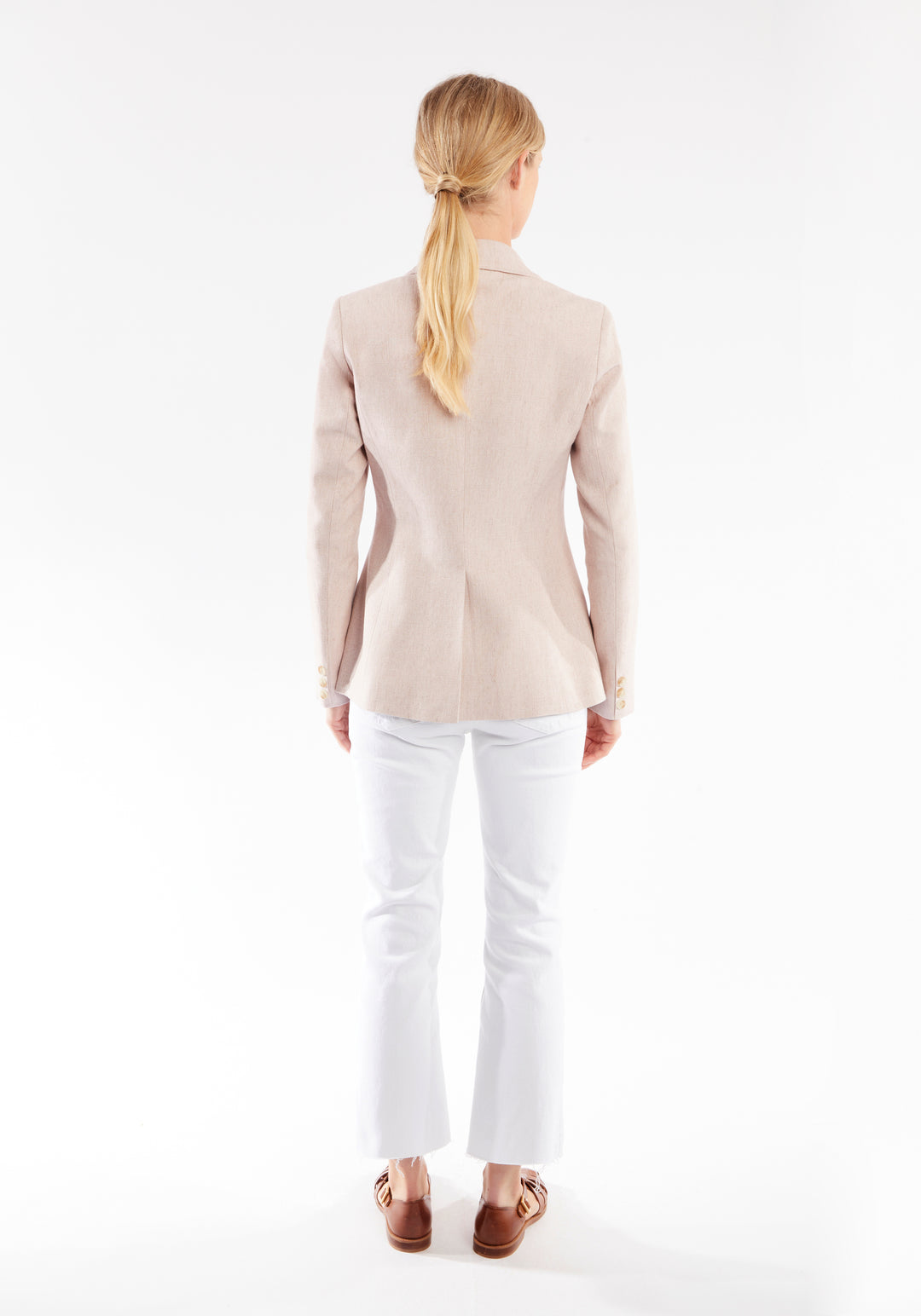 Back of woman wearing light pink jacket 