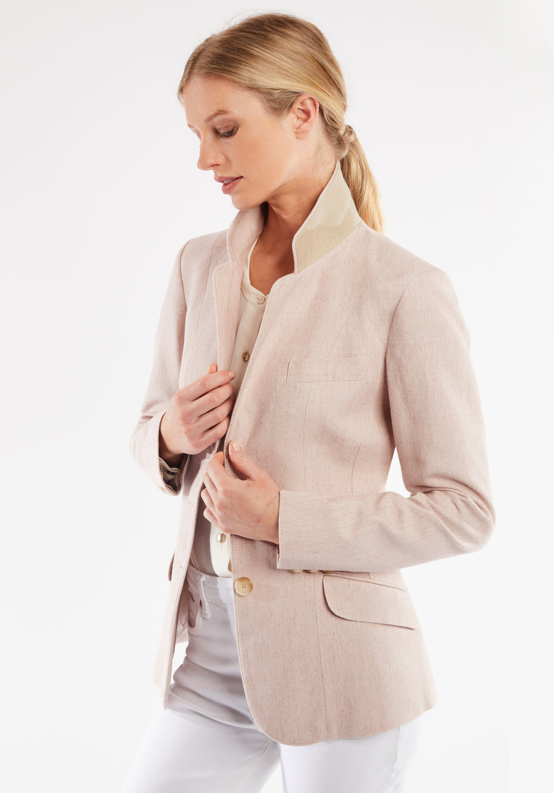 Woman wearing light pink jacket with buttons down the front